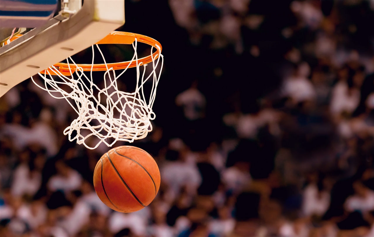 Image of a basketball next to a basketball hoop