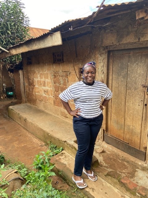 Barbara Mutabazi in front of her house